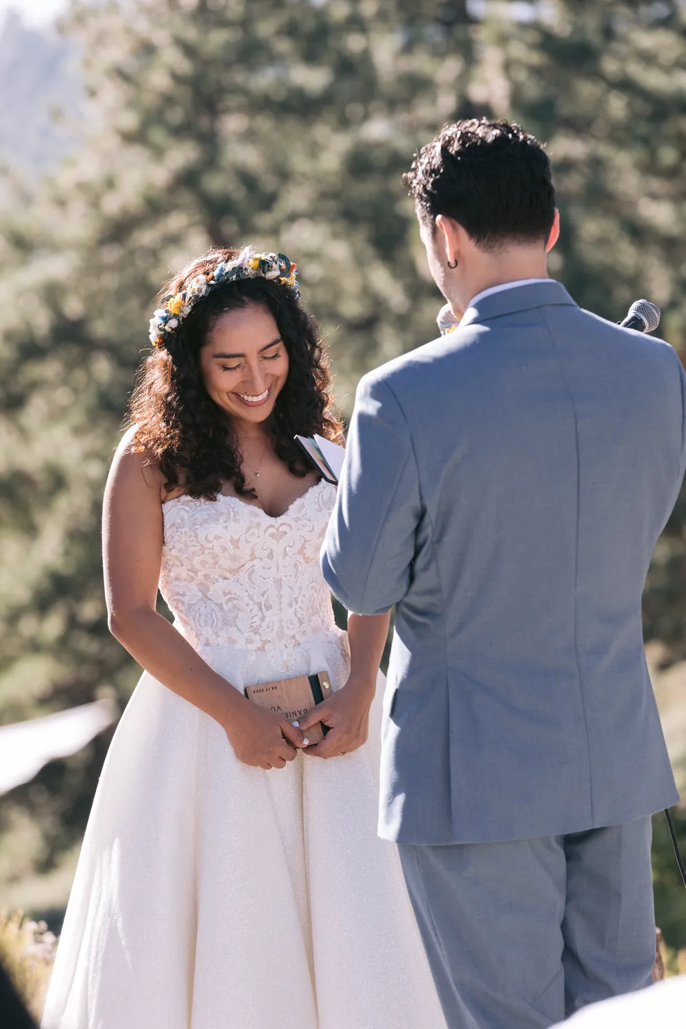 Bride smiling at the groom as they hold hands at the altar